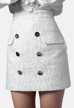 Der Minirock „Claire“ aus edlem italienischem Tweed vereint klassische Eleganz mit einem frischen, modernen Look. Die dezente A-Linie, die doppelte Knopfreihe und der strukturierte Stoff mit feinen Pailletten machen ihn zu einem stilvollen Key-Piece für viele Anlässe. Die edlen Glanzeffekte verleihen dem Rock einen dezenten, aber wirkungsvollen Auftritt – tagsüber wie abends.