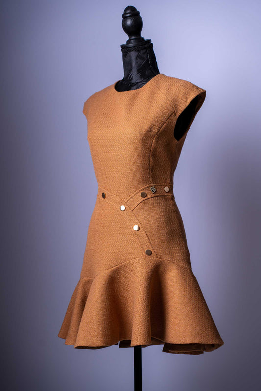Setzen Sie ein modisches Statement mit diesem einzigartigen Mini-Kleid in einem eleganten Camel-Ton. Dieses Kleidungsstück ist die perfekte Mischung aus klassischer Textur und modernem, verspieltem Design.