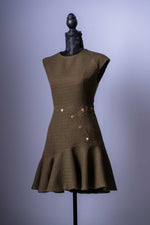 Setzen Sie ein modisches Statement mit diesem einzigartigen Mini-Kleid in einem eleganten Grün. Dieses Kleidungsstück ist die perfekte Mischung aus klassischer Textur und modernem, verspieltem Design.