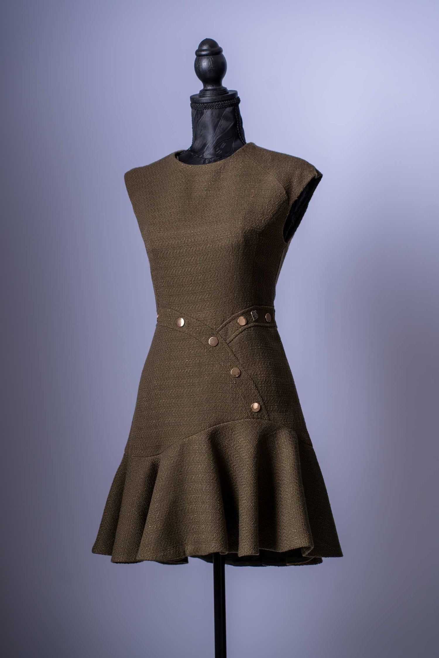 Setzen Sie ein modisches Statement mit diesem einzigartigen Mini-Kleid in einem eleganten Grün. Dieses Kleidungsstück ist die perfekte Mischung aus klassischer Textur und modernem, verspieltem Design.