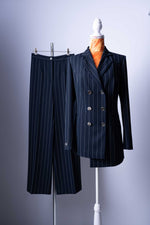 Dieser elegante Damen-Hosenanzug ist die perfekte Wahl für die moderne Frau, die Stil und Selbstbewusstsein ausstrahlt. Das zeitlose Design mit den feinen Nadelstreifen und dem markanten Doppelreiher-Blazer verleiht Ihnen einen kraftvollen und gleichzeitig femininen Look, ideal für das Büro und stilvolle Abendveranstaltungen.