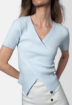 „Lina“ – Feminines Rippstricktop mit Wickeloptik in zartem Hellblau. Handgefertigt in der Schweiz.
