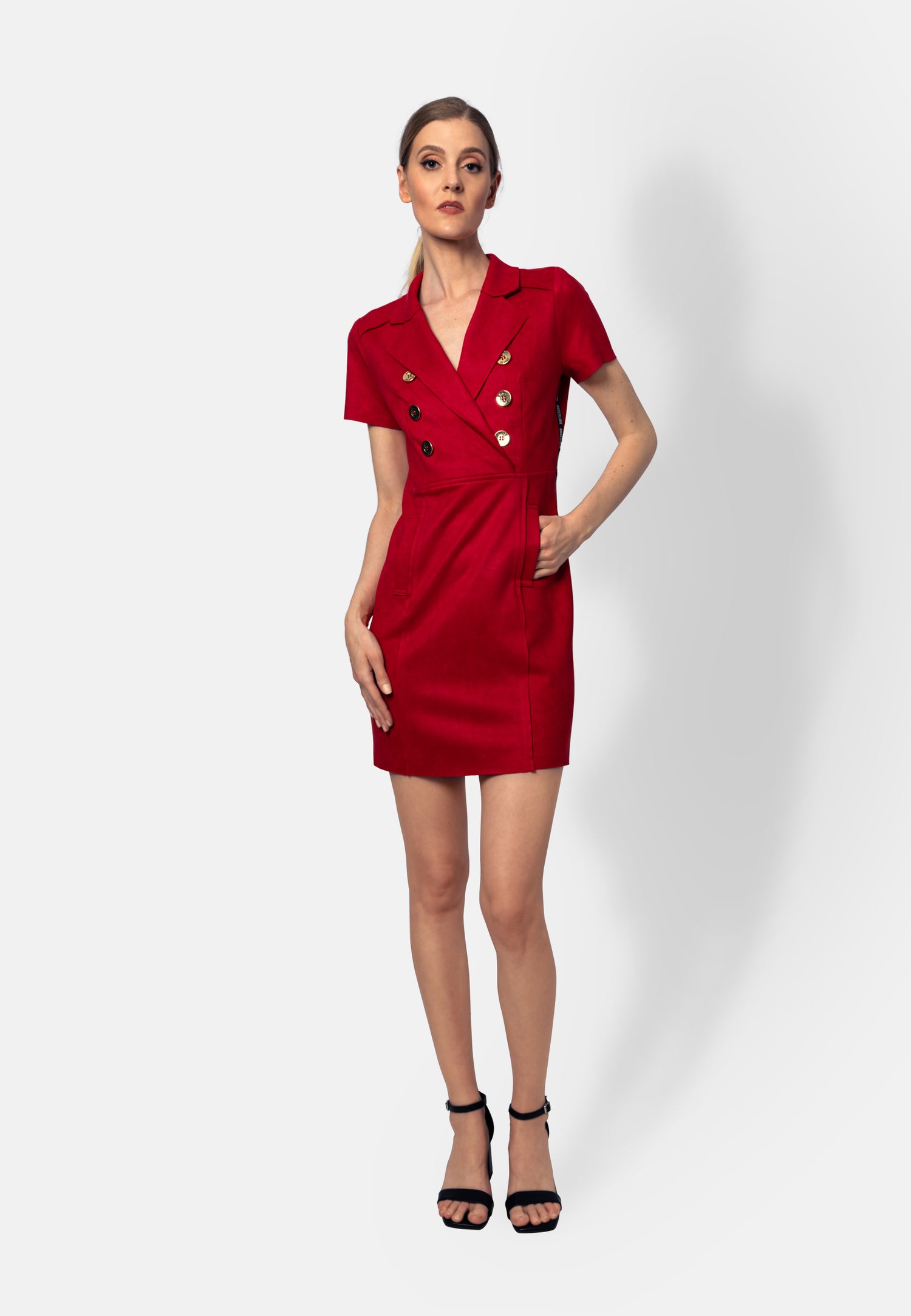 Dieses rote Minikleid aus strukturiertem Ökoleder sitzt figurbetont und verleiht eine starke, selbstbewusste Silhouette. Der sichtbare Reißverschluss vorn sorgt für Komfort und einen modernen Touch, während dekorative Knöpfe und seitliche Zierstreifen mit Branding stilvolle Details setzen.