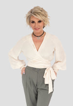 Diese elegante Seiden-Wickelbluse "Champagner" ist ein absolutes Highlight. Sie ist aus einer luxuriösen Mischung aus 85 % Seide und 35 % Polyamid gefertigt, die für einen weichen, fließenden Fall sorgt und ein angenehmes Tragegefühl garantiert. Die langen Ärmel und der feminine Cache-Cœur-Ausschnitt betonen die Figur auf stilvolle Weise.