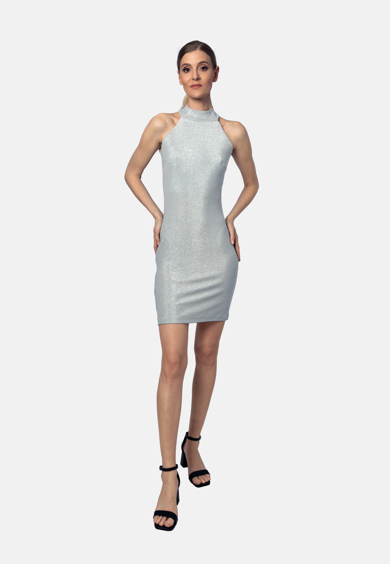 Dieses silbergraue Minikleid aus hochwertigem, elastischem Viskose-Jersey aus Italien mit weichem Lurex, der dem Kleid einen auffälligen Glanz verleiht, vereint Eleganz, Komfort und zeitlose Raffinesse. Der figurbetonte Schnitt und die kurze, moderne Länge sorgen für eine verführerische Silhouette, während edle Zierelemente mit Strasssteinen dem Design eine luxuriöse Note verleihen.