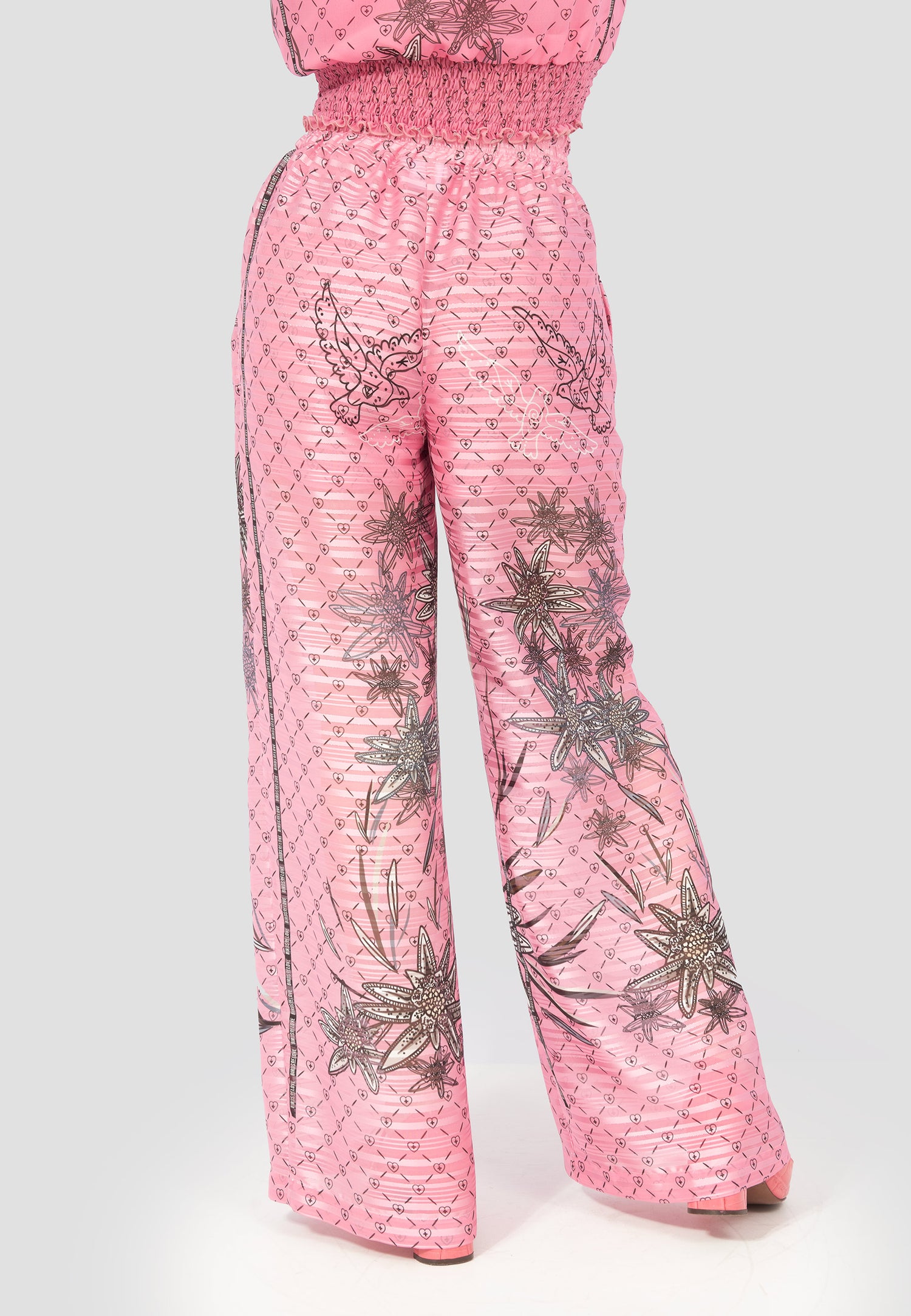 Edelweiss-Jumpsuit in Rosa mit langen Ärmeln und floralem Muster – handgefertigte Schweizer Trachtenmode von Birds of Love in moderner Interpretation.

